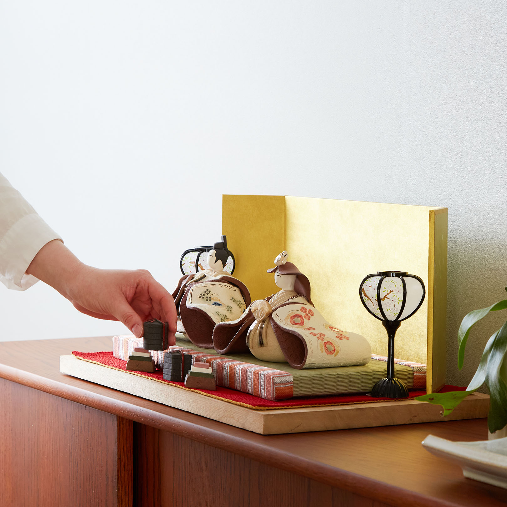 小物をを増やしたり、自分だけのカスタマイズできる信楽焼の雛人形を飾る様子