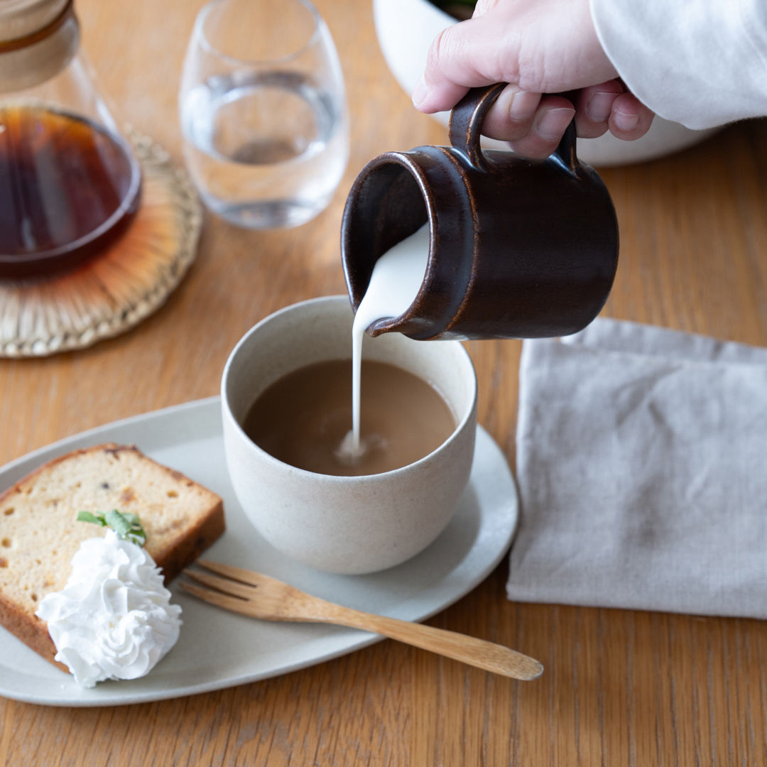 鉄茶色のドレッシングピッチャーでミルクを注ぐシーン